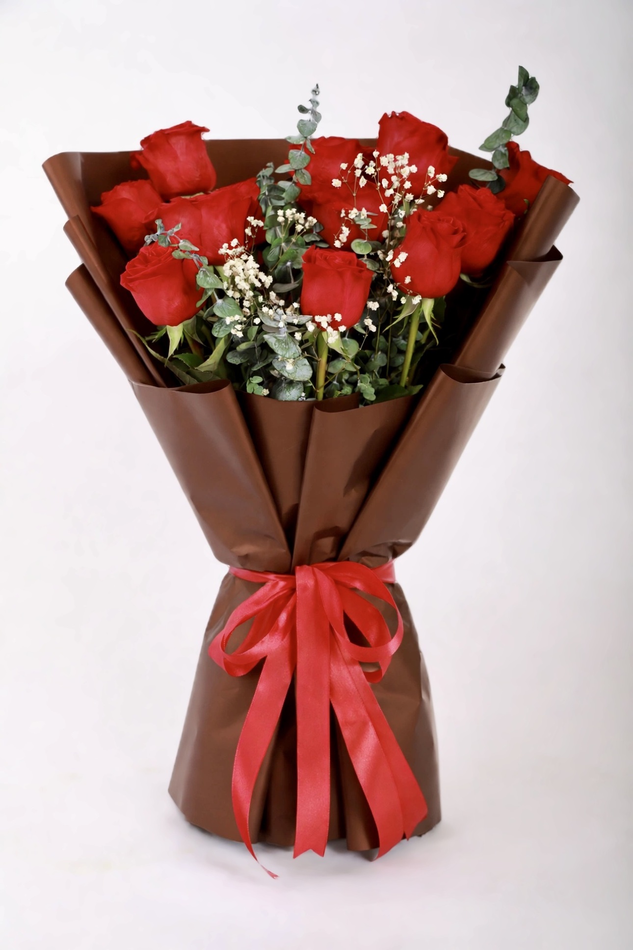 Ember Rose Bouquet — red roses with baby's breath and eucalyptus in deep brown wrap, tied with a red satin bow